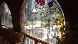 Une pièce dotée d’une grande fenêtre à vitraux ornés de motifs floraux.