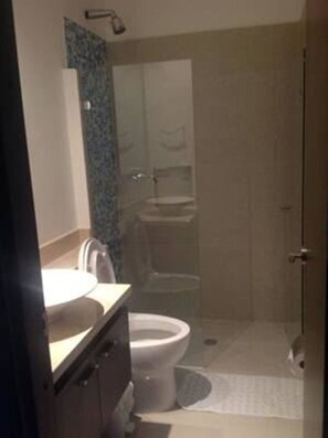 A bathroom with a toilet, sink, and shower area. - Palmetto Eliptic Apartamentos (Cartagena de Indias)
