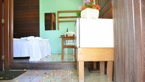 A room with a bed, a small table, and a chair.