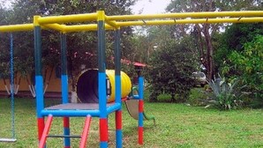 A playground with a yellow and blue play structure, including a slide and a climbing area. - Finca 028 (Restrepo)