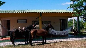 A building with a corrugated metal roof and a porch area. - Finca 028 (Restrepo)