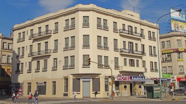 A multi-story hotel with balconies, a ground-level entrance, and a visible sign for HOTEL AmericA. - Gran Hotel America (Buenos Aires)