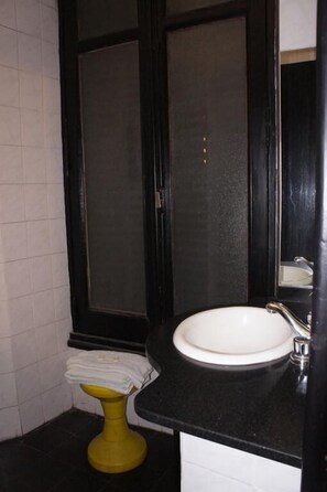 A bathroom with a white sink, a yellow pedestal toilet, and a large mirror. - Gran Hotel America (Buenos Aires)
