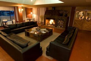 Ein gemütliches Wohnzimmer mit Kamin, Ledersofas und einem Couchtisch.