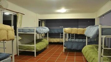 Un dormitorio con literas, una ventana con cortinas y suelo de baldosas.