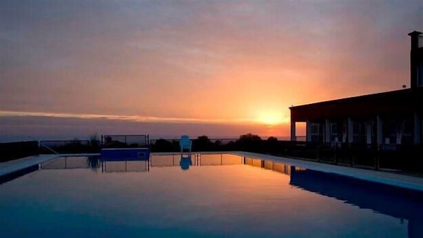 Een zwembad in de zonsondergang met een heldere lucht.