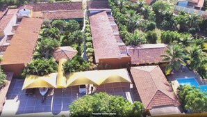 A resort with multiple buildings, a swimming pool, and lush greenery.
