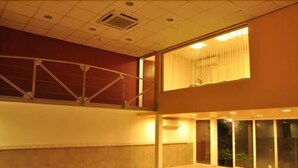 A spacious indoor area with a balcony, large windows, and a ceiling with recessed lighting. - Hotel Osam (Buenos Aires)