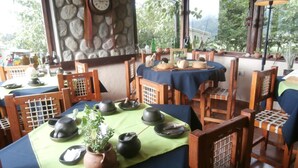Un ristorante tradizionale giapponese, con sedute su tatami e un fondo parete in pietra.