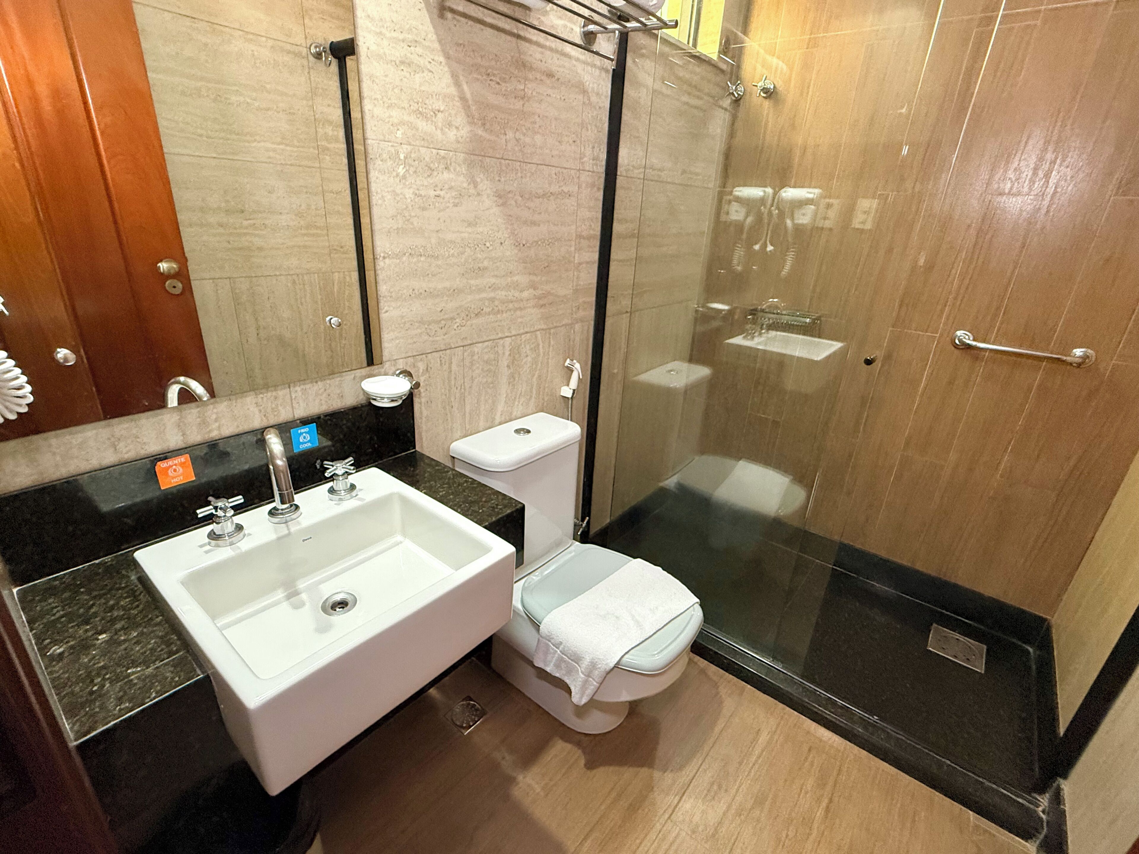 A modern bathroom with a sink, toilet, and glass-enclosed shower.