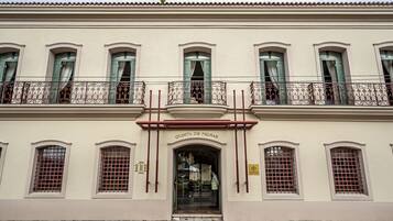 Classic architecture meets elegant entrance at Quinta de Pedras, featuring a symmetrical facade with central entrance and ornate metal railings.