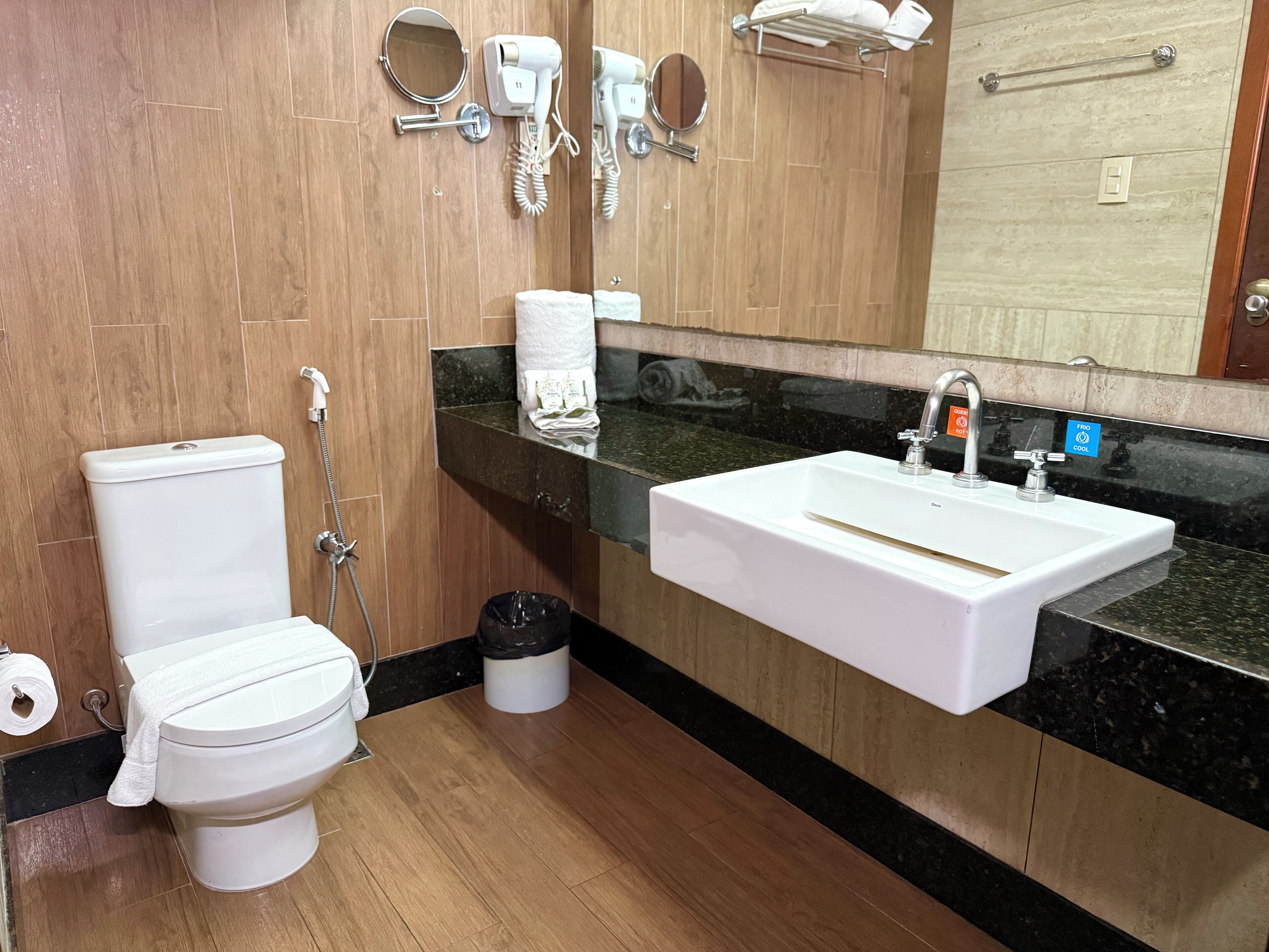 Une salle de bain équipée de toilettes, d’un lavabo et d’un porte-serviettes.