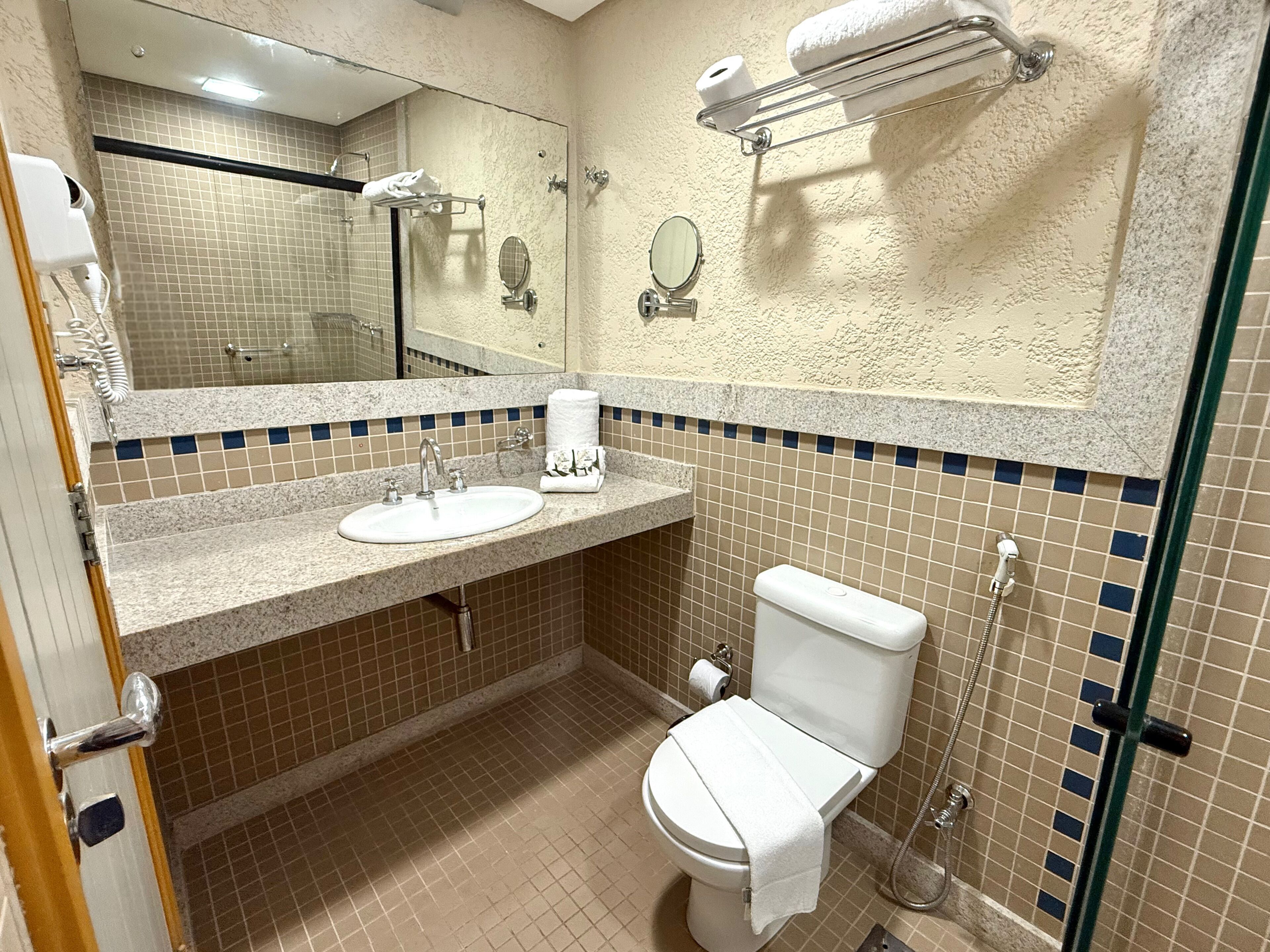 A bathroom with a sink, toilet, and shower.