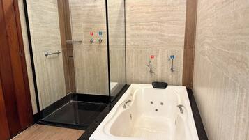 Une salle de bain moderne avec une douche à parois de verre, une baignoire blanche et des murs recouverts de carrelage.