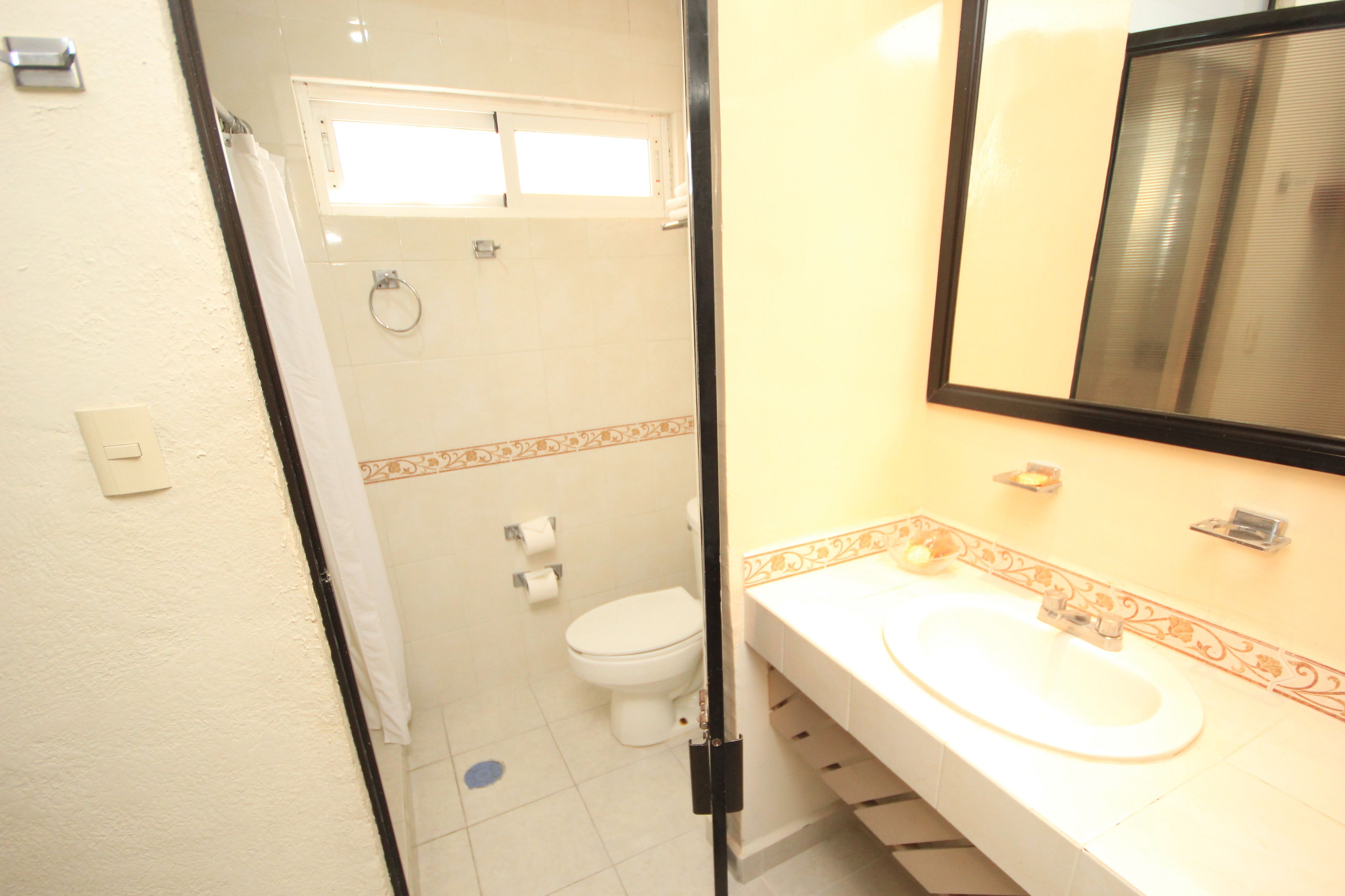 A bathroom with a white sink, a mirror, and a toilet.