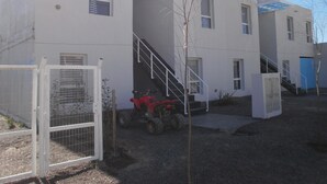 A multi-story building with a staircase leading to the upper floor. - Departamentos El Terrado II (Las Grutas)