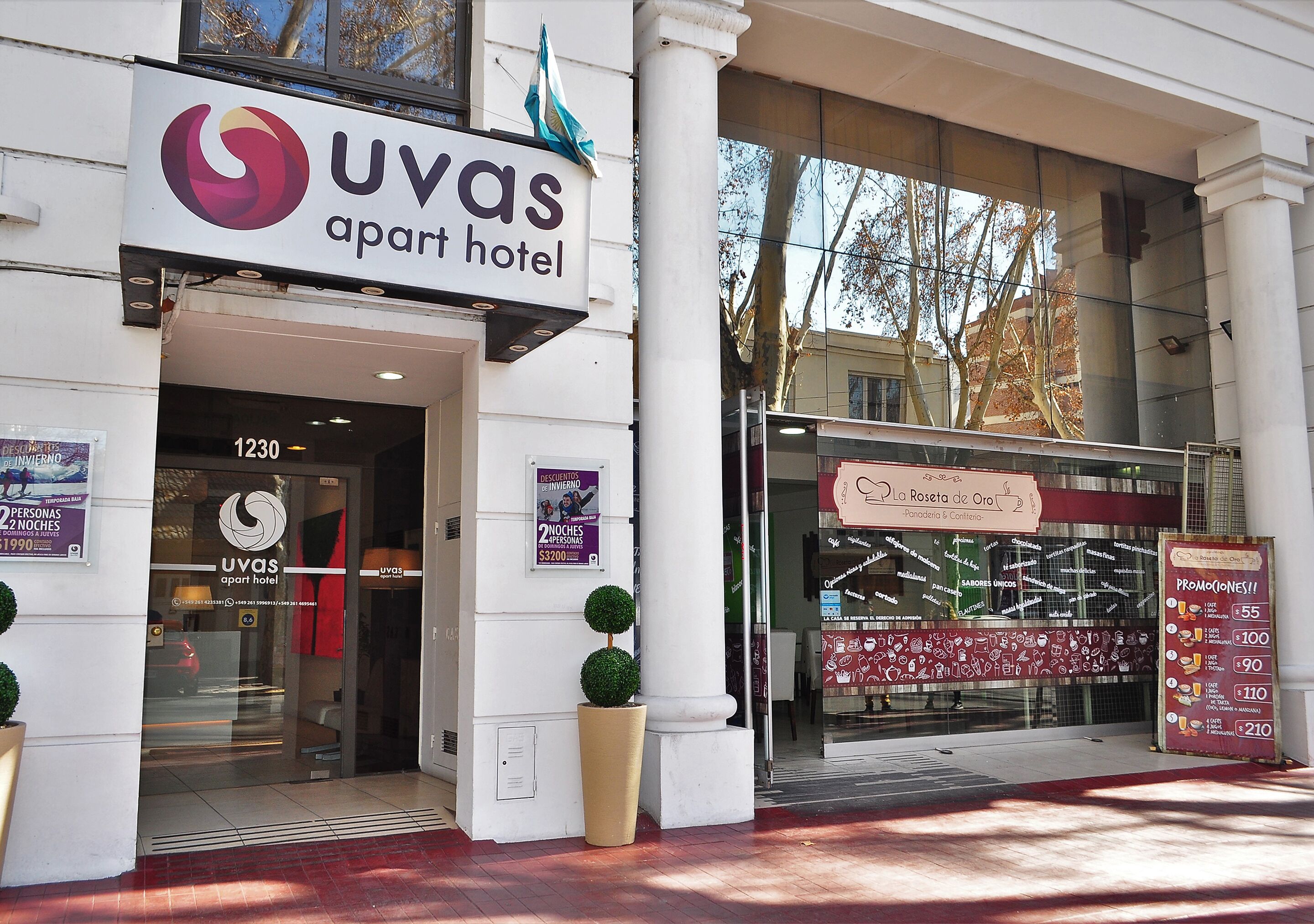 The UVAS apartment hotel entrance with a modern facade, large windows, and a visible restaurant sign.