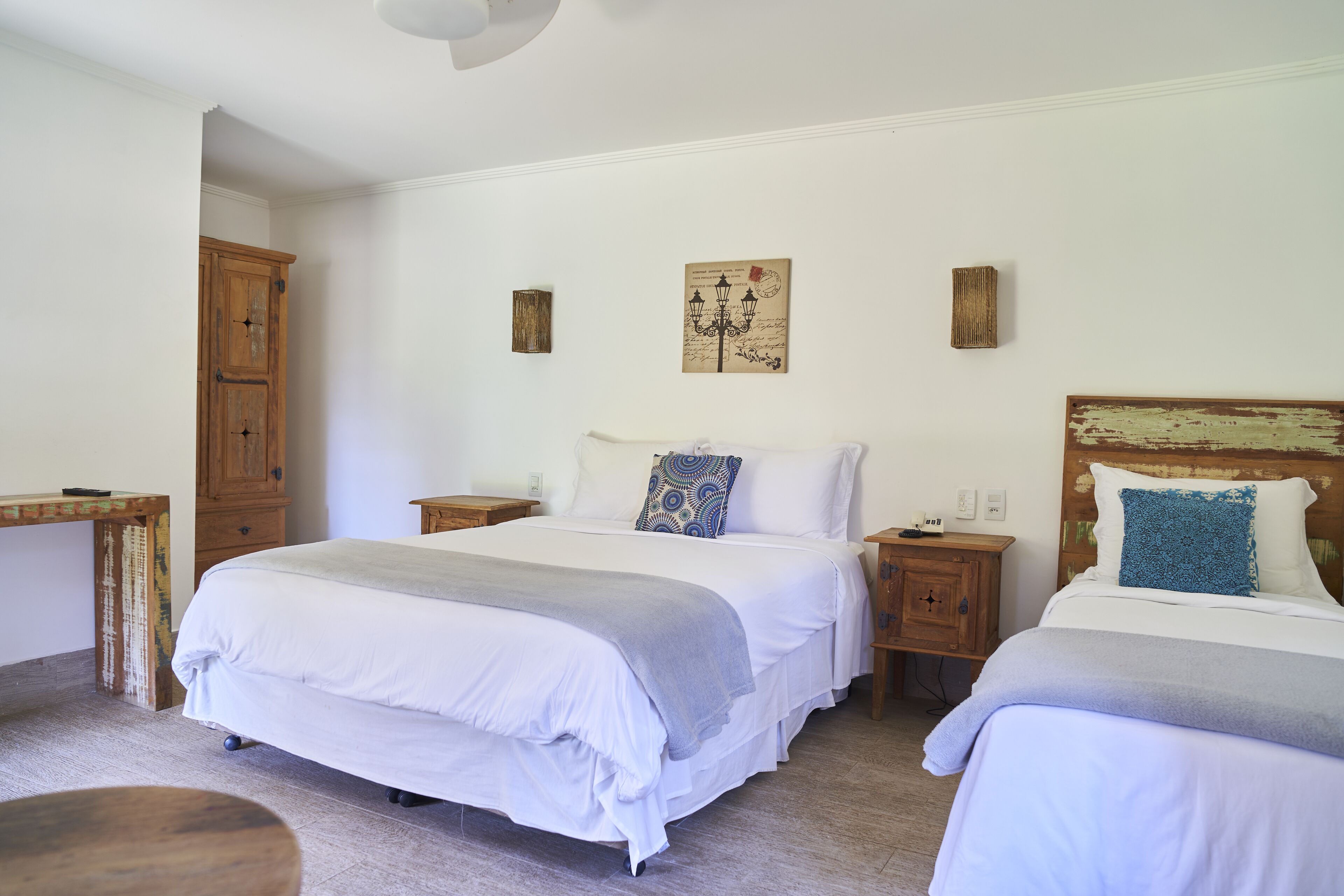 Een slaapkamer met twee bedden, houten meubels en wandlampen.