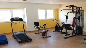 A gym with cardio equipment, weight machines, and a bench. - Hotel Dora (Termas de Rio Hondo)