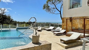 A pool area with lounge chairs, a diving board, and a view of the ocean. - Jaina Resort & Spa (Mar de Las Pampas)