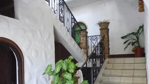Una escalera con un muro de piedra, una puerta de madera y plantas en macetas.