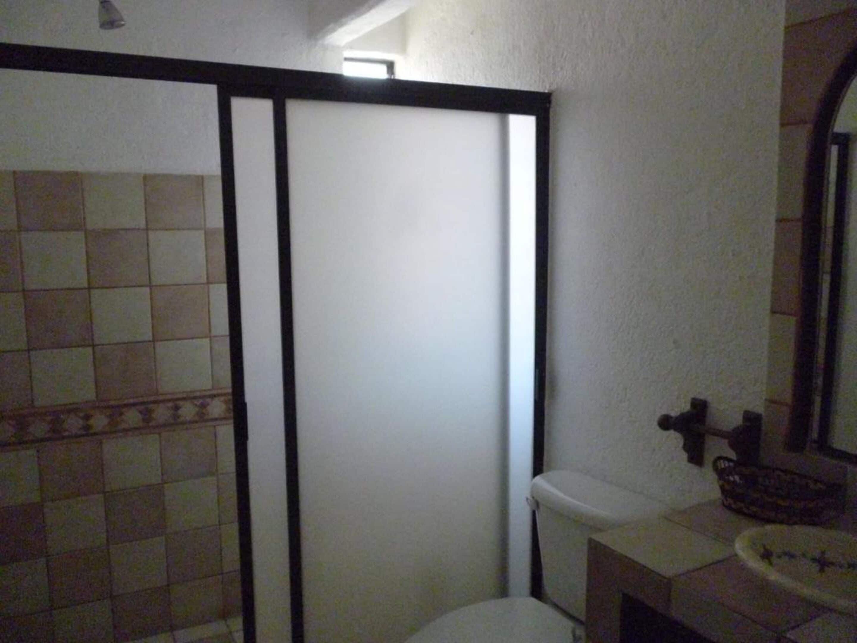 Une salle de bain avec des toilettes, un lavabo et un miroir.