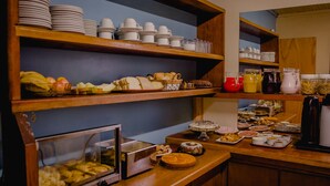 Un buffet proposant une variété de plats et de boissons, présentés sur des étagères et des comptoirs en bois.