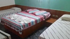 A single-bed room with a wooden headboard, a striped blanket, and a white pillow. - Bica Pau Hotel Thermas (Caldas Novas)
