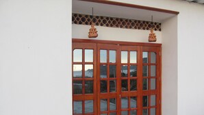 A wooden door with glass panels, a decorative ceiling, and a view of mountains and a body of water. - Casa Tara (Santa Marta)