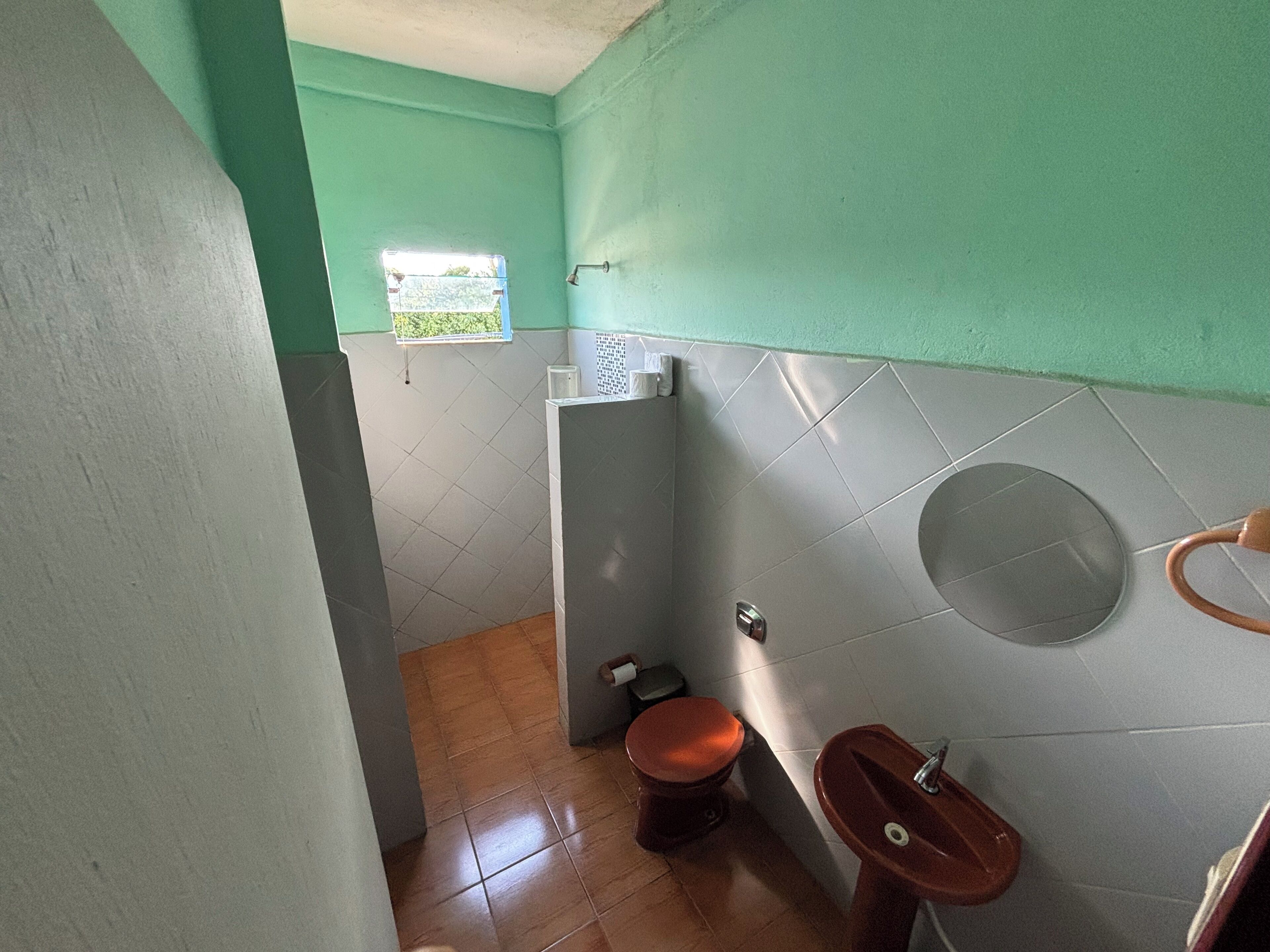 Un baño pequeño con inodoro, lavamanos y ventana.