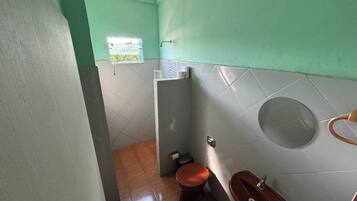 Un baño pequeño con inodoro, lavamanos y ventana.