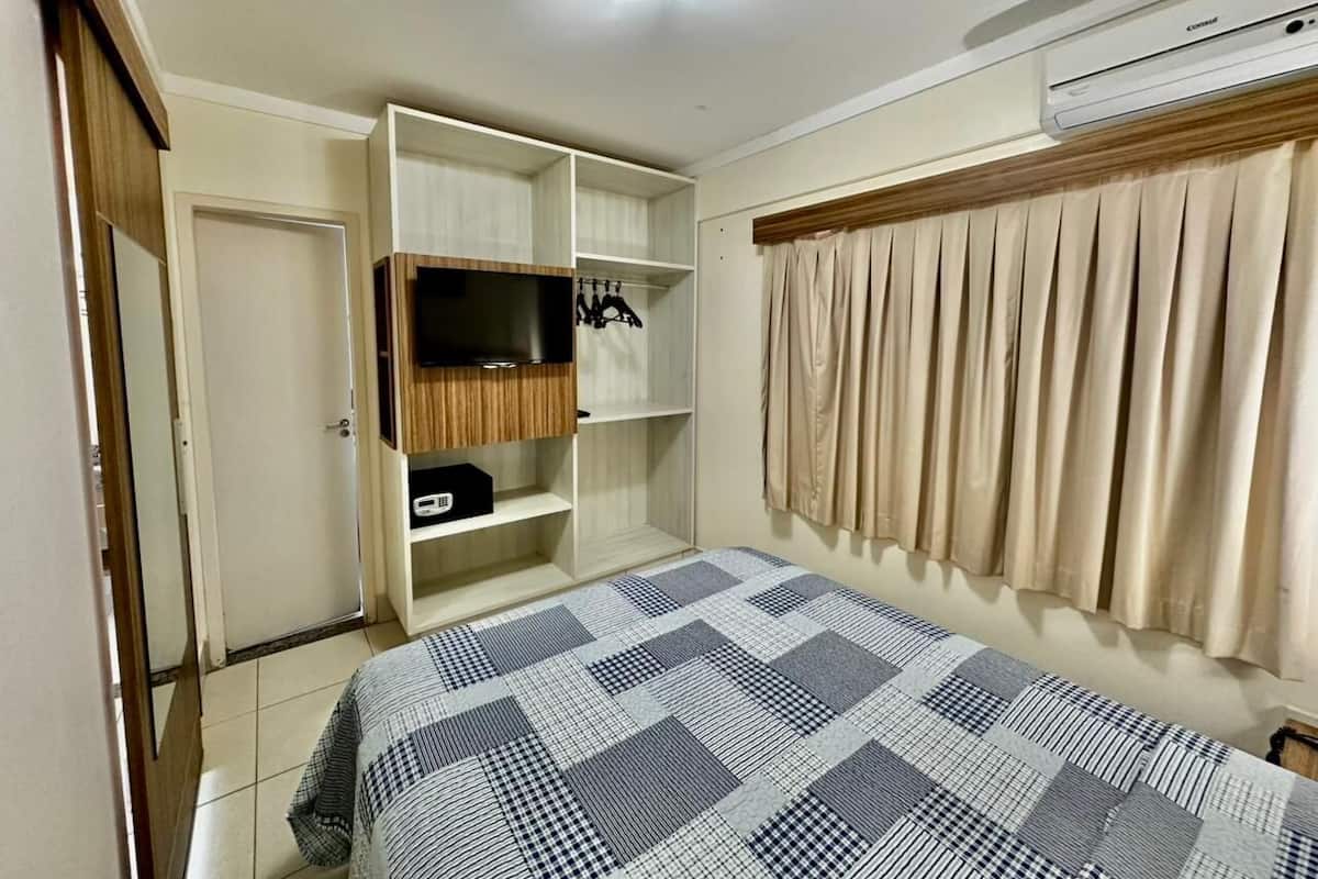 Une chambre à coucher comprenant un lit, une armoire et un appareil de climatisation.