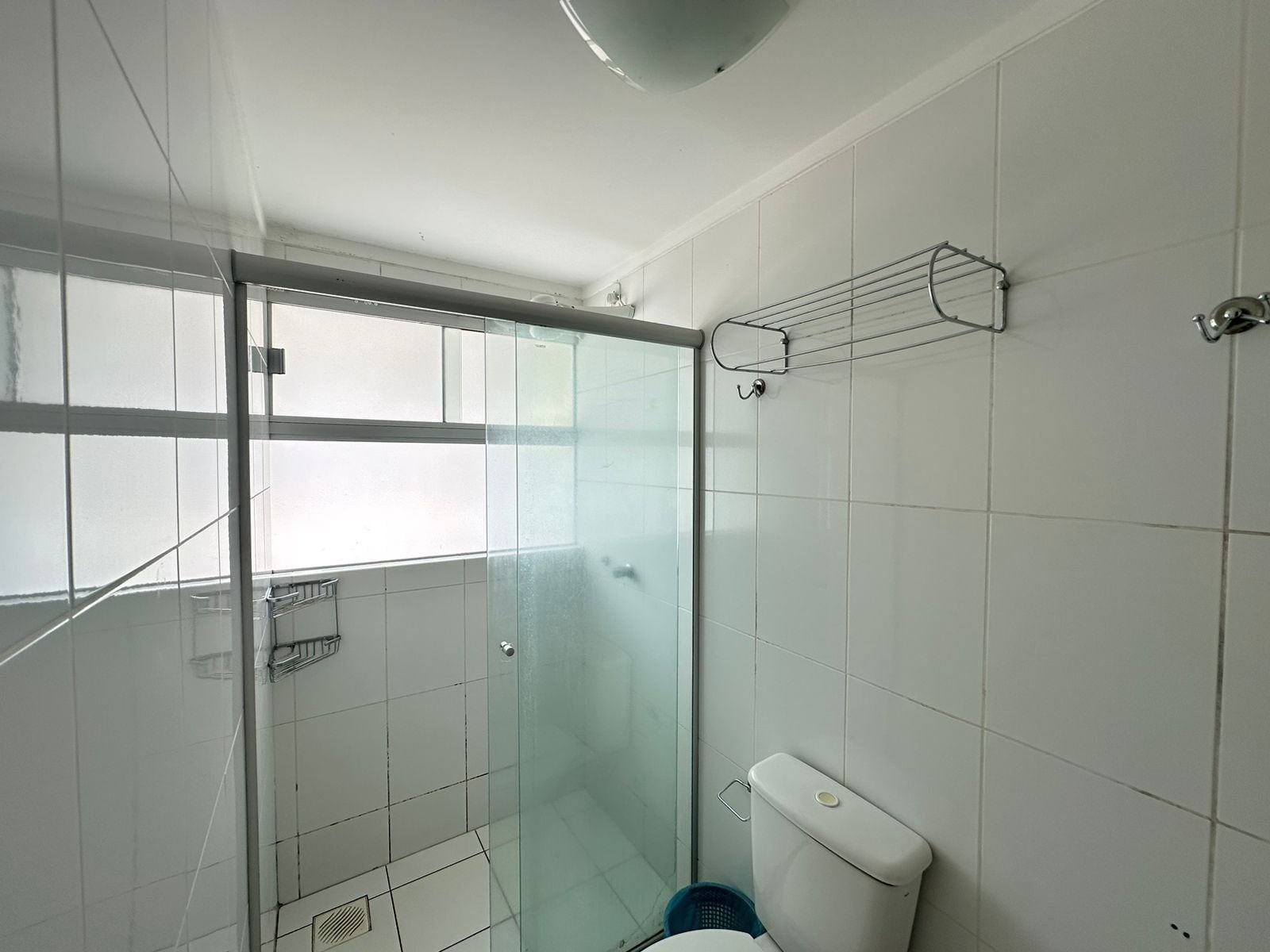 Un bagno con doccia vetrata, un water e un porta asciugamani.