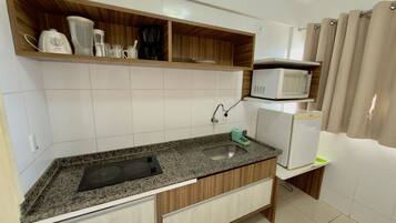 A kitchen with a granite countertop, built-in microwave, and wooden cabinets.