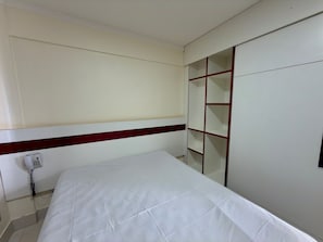 A bedroom with a bed, a telephone, and a wardrobe with a red frame. - Lacqua Di Roma I Via Caldas (Caldas Novas)
