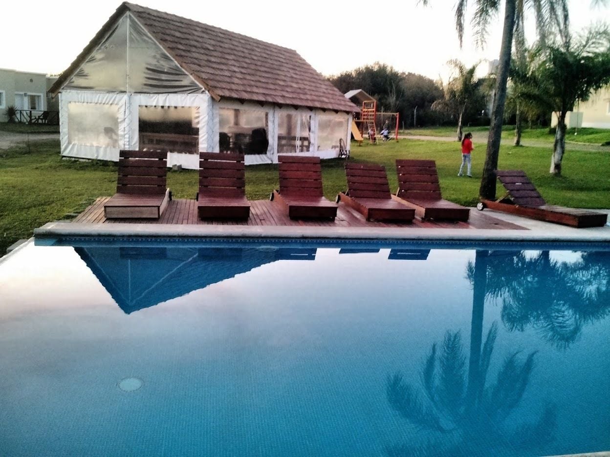 Una piscina amb gandules i un petit pabelló.
