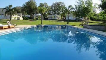 Een buitenzwembad en ligstoelen