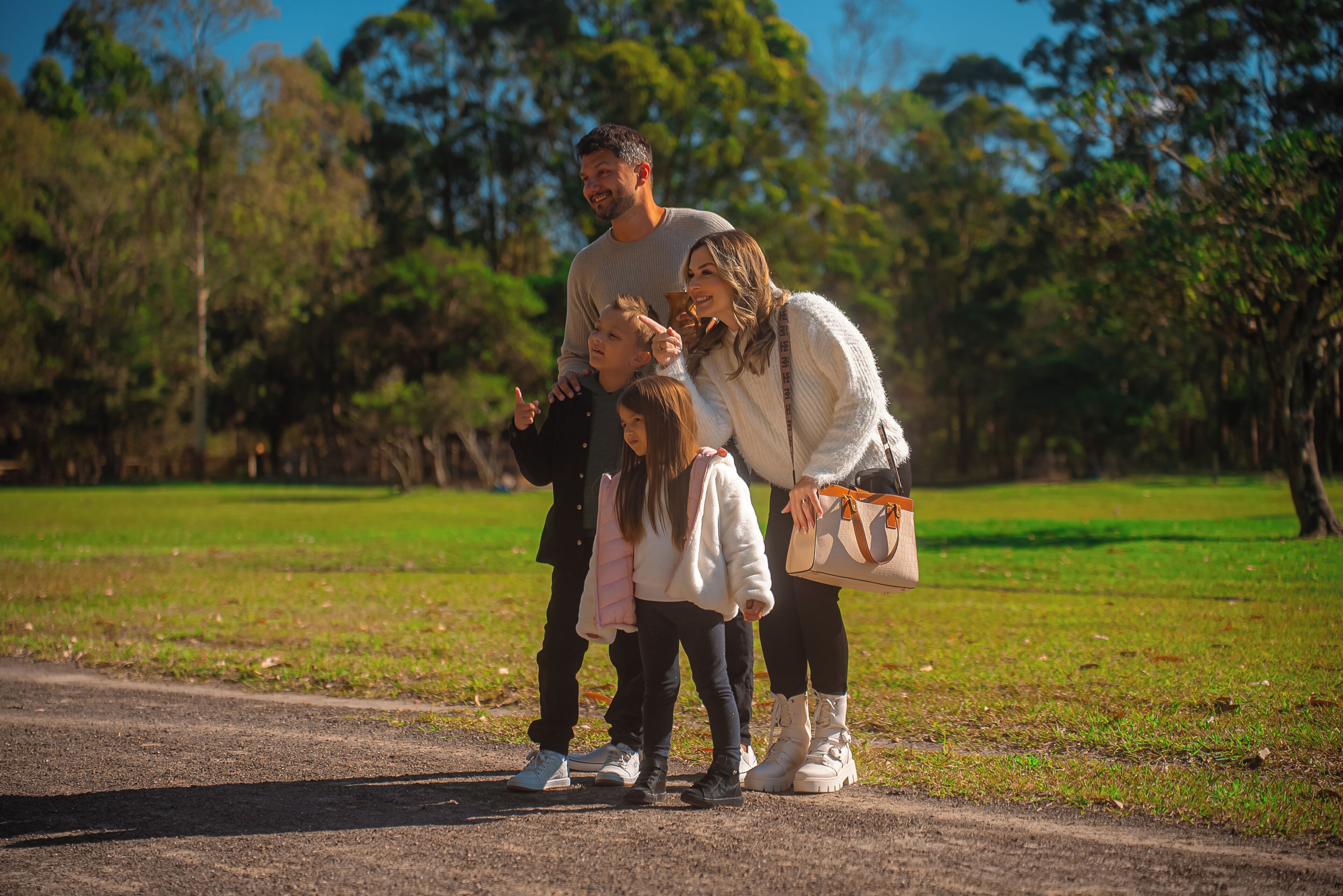 A family of four in a park with a dirt path.