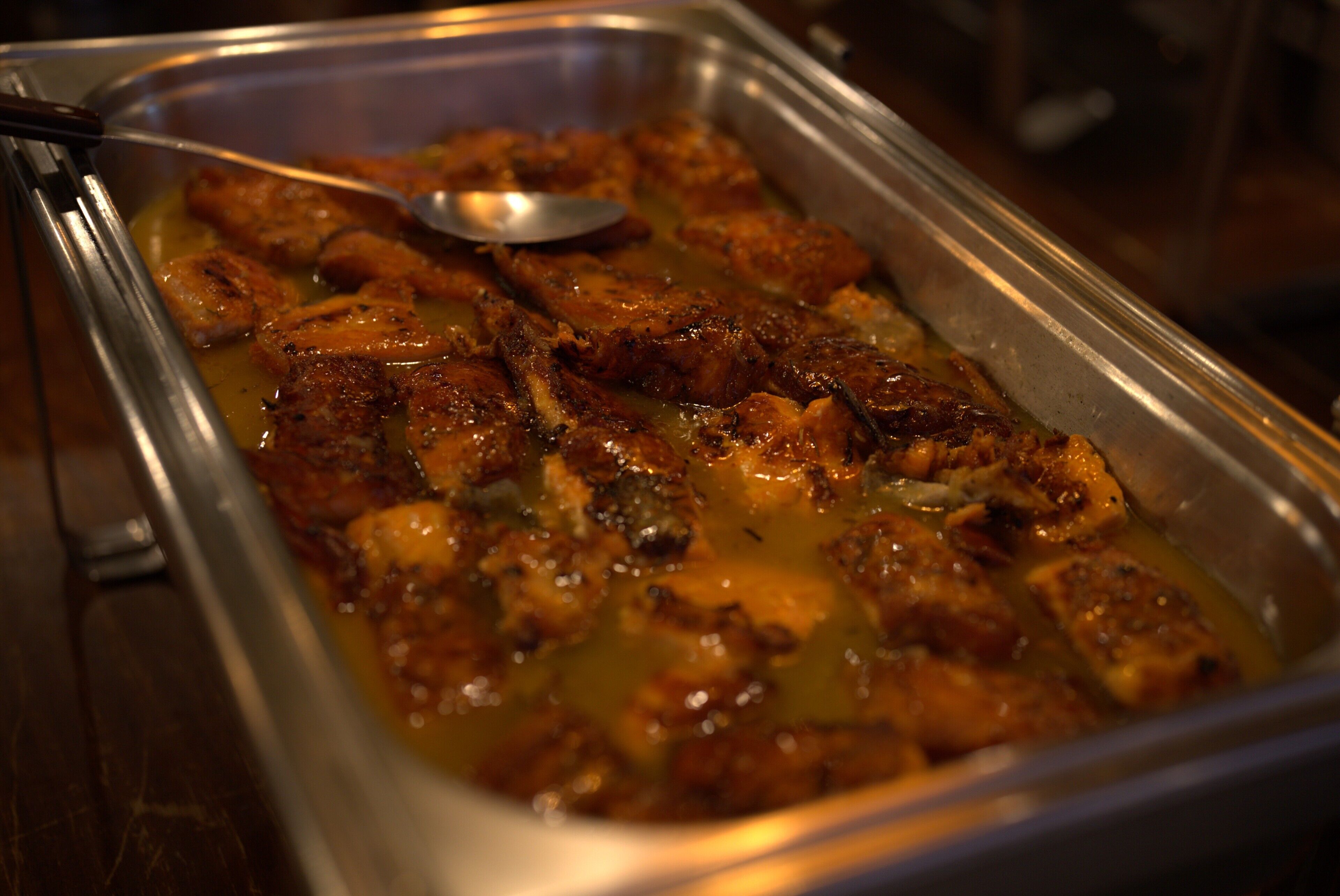 A buffet with a variety of food items, including what appears to be glazed chicken and other dishes.