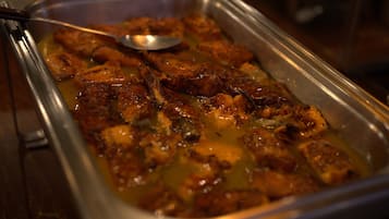 A buffet with a variety of food items, including what appears to be glazed chicken and other dishes.