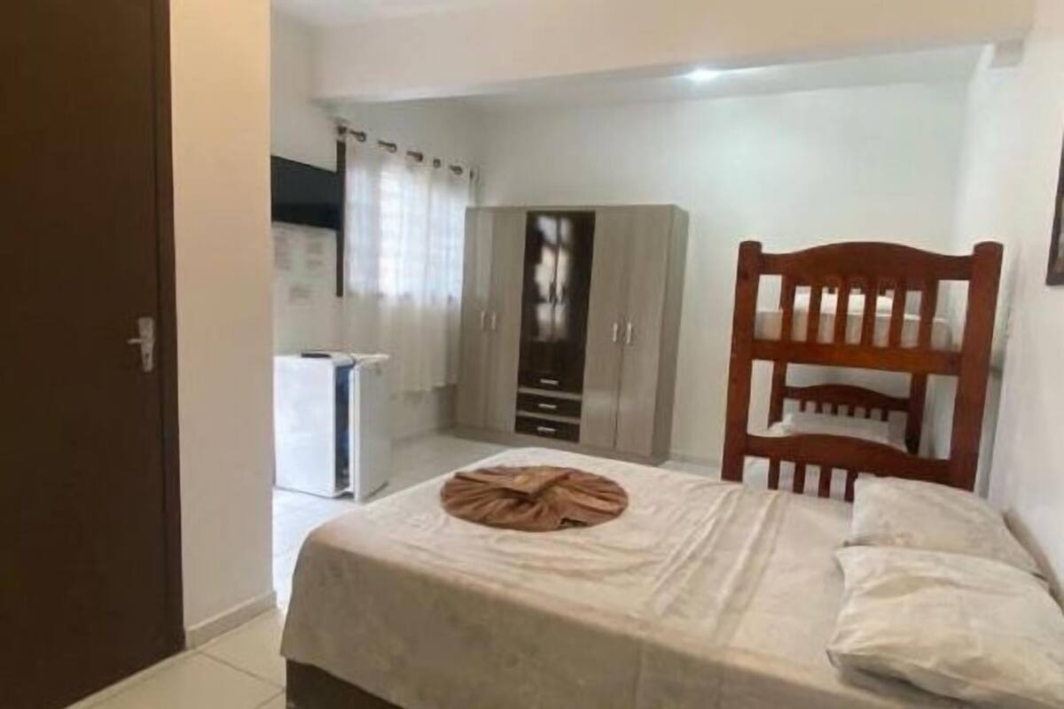 A bedroom with a bed, a wooden headboard, a wardrobe, and a radiator.