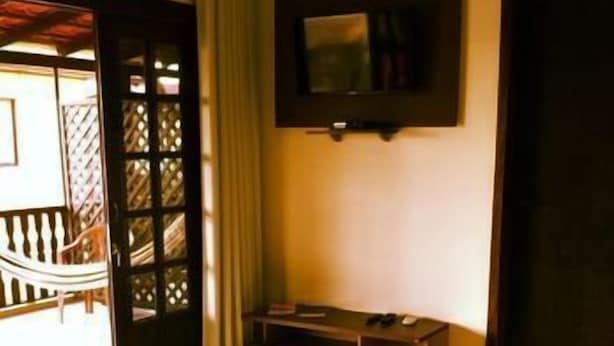 Una habitación con cama, escritorio, televisor y vistas al exterior.