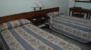 A room with two single beds, a nightstand with a lamp, and a small desk with a chair. - Hostería ACA Tafí del Valle (Tafi del Valle)