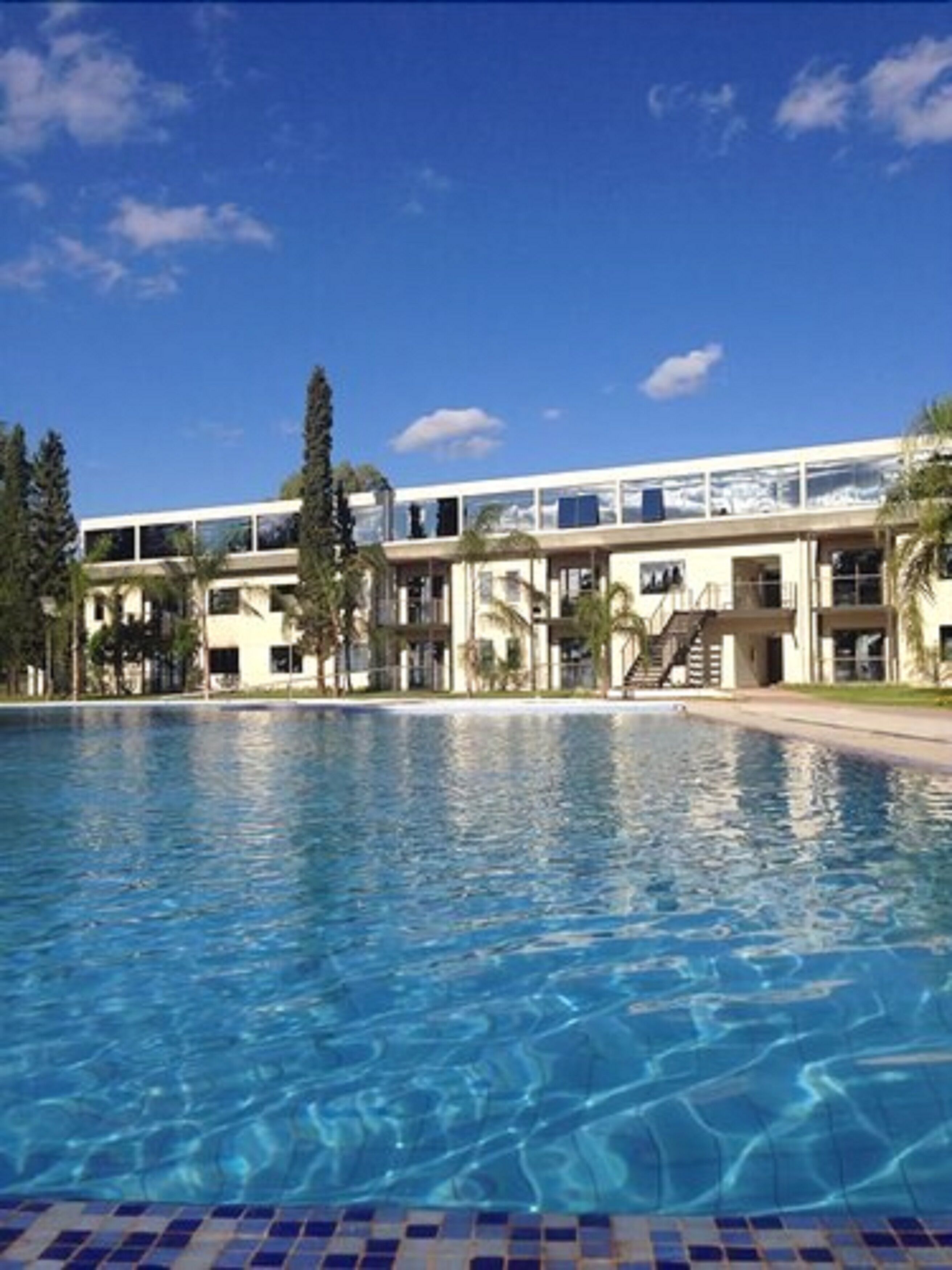 A swimming pool with a modern building in the background.