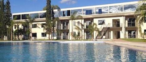 A swimming pool with a modern building in the background.