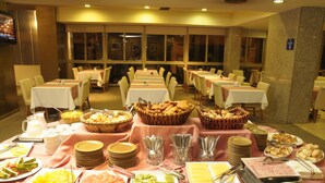 A buffet setup with various food items and utensils. - Ariston Hotel (Rosario)