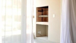 Ein Zimmer mit einem runden Tisch, einem gestreiften Sofa und einem Schrank mit Spiegel.