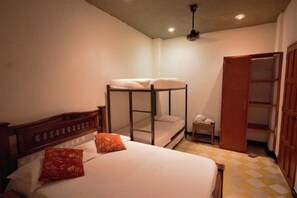 Un dormitorio con una cama individual, una cama litera y un armario.