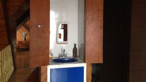 A bathroom with a blue sink, a mirror, and a bottle of hand soap. - Bed & Breakfast Chaletico (San Jose)