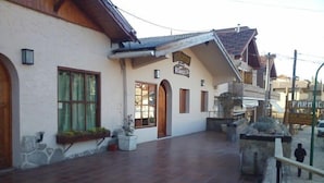 Ein Gebäude mit einer gefliesten Terrasse, einer Holztür und einem Schild mit der Aufschrift 'Resort'.